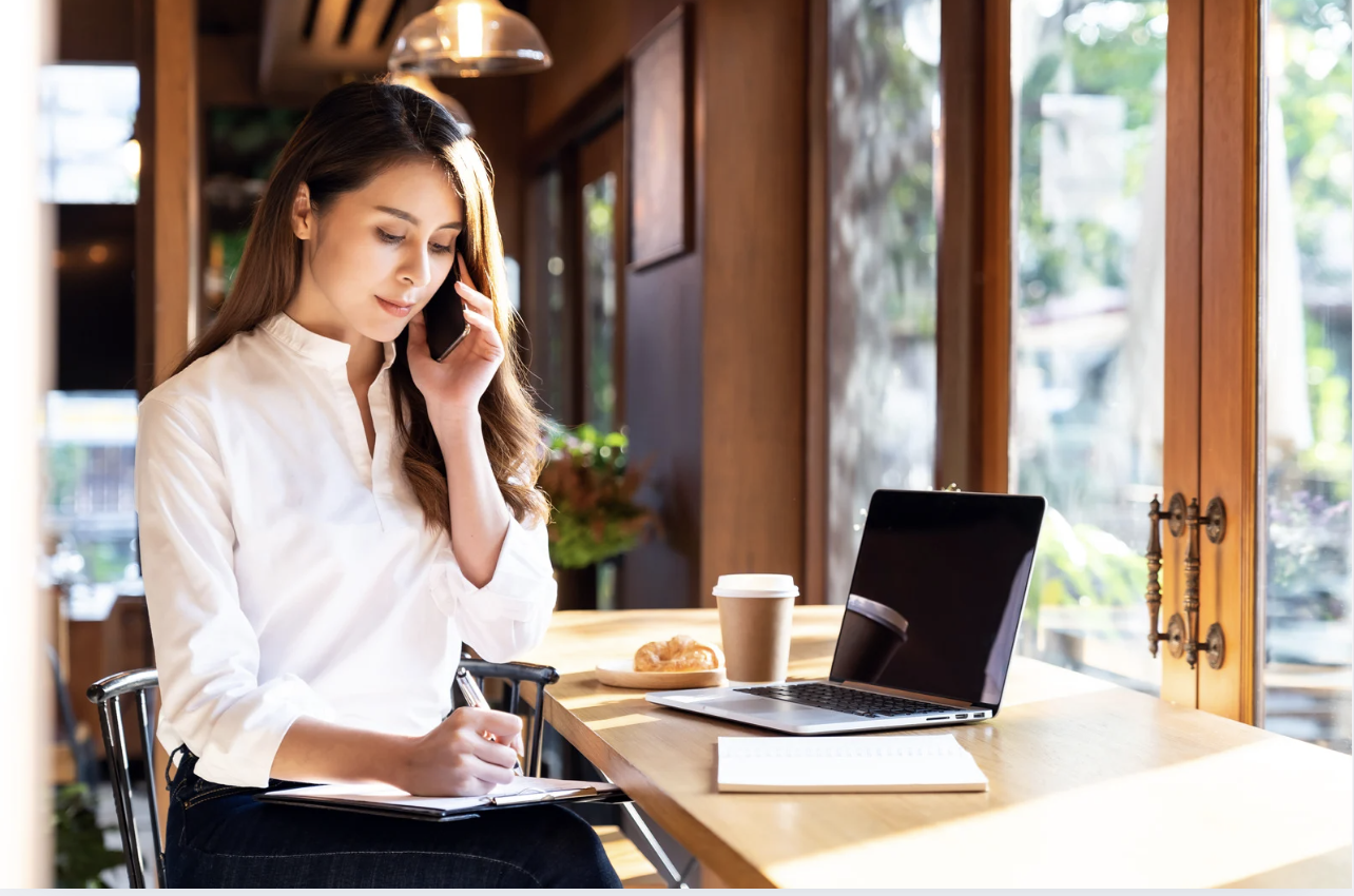woman on phone with laptop